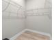 Well-organized walk-in closet with white wire shelving and light hardwood flooring, offering ample storage space at 205 E 17Th St, Apopka, FL 32703