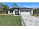 Charming single-story home with a well-manicured lawn and a paved driveway leading to an attached garage at 205 E 17Th St, Apopka, FL 32703