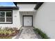 Inviting entryway with a stylish stone walkway leading to a double front door framed by black trim at 205 E 17Th St, Apopka, FL 32703