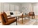 Cozy living room featuring a plush white sofa, leather armchairs, and an elegant coffee table arrangement at 205 E 17Th St, Apopka, FL 32703