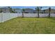 Large backyard with new sod, palm trees and a white vinyl fence in a residential neighborhood at 1162 Happy Forest Loop, Deland, FL 32720