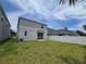 Well-maintained backyard featuring lush green grass, a white fence, and a sliding glass door entrance at 1162 Happy Forest Loop, Deland, FL 32720