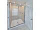 Modern bathroom featuring a frameless glass shower with tiled walls, and a door leading to the outside at 1162 Happy Forest Loop, Deland, FL 32720