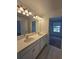 Bright bathroom with a double vanity, modern lighting fixtures, and a door to another room at 1162 Happy Forest Loop, Deland, FL 32720