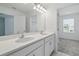 Bathroom with double sink vanity, white cabinets, an oversized mirror and access to the bedroom at 1162 Happy Forest Loop, Deland, FL 32720