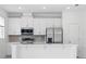 Modern kitchen featuring stainless steel appliances, sleek white cabinets, and a stylish tiled backsplash at 1162 Happy Forest Loop, Deland, FL 32720