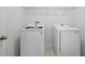 Bright laundry room features a white washer and dryer, as well as convenient upper shelving at 1162 Happy Forest Loop, Deland, FL 32720