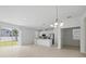 Bright open floor plan with neutral tile flooring leads into a modern kitchen with stainless appliances at 1162 Happy Forest Loop, Deland, FL 32720