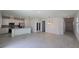 Open-concept living room featuring light-colored tile flooring, and a kitchen with stainless steel appliances at 1162 Happy Forest Loop, Deland, FL 32720