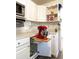 Efficient kitchen corner featuring white cabinetry with custom pull-out shelves for appliances and extra storage at 1311 Hartley Ave, Deltona, FL 32725