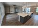 Spacious kitchen island with a farmhouse sink, leading to a living area with a modern ceiling fan and recessed lighting at 0 Oberly Pkwy, Orlando, FL 32833