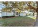 House exterior featuring a light gray house with a large tree in the front yard at 541 Willet Cir, Auburndale, FL 33823