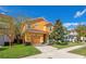 Two-story home with tile roof, well-manicured lawn, mature trees, and a two-car garage, creating a warm curb appeal at 2948 Banana Palm Dr, Kissimmee, FL 34747