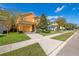 Two-story home with tile roof, well-manicured lawn, mature trees, and a two-car garage, creating a warm curb appeal at 2948 Banana Palm Dr, Kissimmee, FL 34747