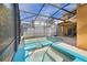 Screened in patio with private pool and connected hot tub, next to a set of patio furniture for lounging at 2948 Banana Palm Dr, Kissimmee, FL 34747