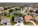 Scenic aerial view of a neighborhood with mature trees, lush lawns, and meticulously maintained homes at 349 Plantation Club Dr, Debary, FL 32713