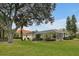 Landscaped backyard with screened patio and large oak tree at 349 Plantation Club Dr, Debary, FL 32713