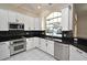 Modern kitchen with white cabinets, granite countertops, and stainless steel appliances at 349 Plantation Club Dr, Debary, FL 32713