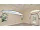 Spacious living room with arched windows, hardwood floors and access to a patio at 349 Plantation Club Dr, Debary, FL 32713