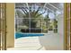 View of the screened-in pool area through open French doors, offering a private outdoor retreat at 349 Plantation Club Dr, Debary, FL 32713