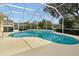 Beautiful in-ground swimming pool inside a screened enclosure with lush landscaping at 349 Plantation Club Dr, Debary, FL 32713