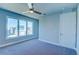Bright bedroom featuring neutral walls, carpeted floors, ceiling fan and a large window that offers lots of natural light at 7760 Sandy Ridge Dr # 222, Kissimmee, FL 34747