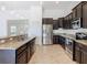 Modern kitchen featuring stainless steel appliances, granite countertops, and dark wood cabinets with tile floors at 8914 Dove Valley Way, Davenport, FL 33896