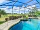 Gorgeous pool and spa area with screened enclosure, waterfall feature, and lush green golf course views at 8914 Dove Valley Way, Davenport, FL 33896