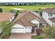 Expansive home featuring a clay tile roof, three-car garage, brick driveway and landscaping, on a golf course at 8914 Dove Valley Way, Davenport, FL 33896