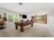 Spacious game room features a pool table, rustic wood accents, and two large windows at 698 Mt Pleasant Dr, Ocoee, FL 34761