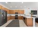 Well-lit kitchen boasting wooden cabinets, stainless steel appliances, and an eat-in island for casual dining at 698 Mt Pleasant Dr, Ocoee, FL 34761