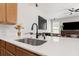 Close-up of a kitchen island with a stainless steel sink, matte black faucet, and quartz countertops at 698 Mt Pleasant Dr, Ocoee, FL 34761
