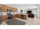 Open-concept kitchen with modern appliances, wooden cabinets, and a view of the living room at 698 Mt Pleasant Dr, Ocoee, FL 34761