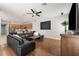 Spacious living room with hardwood floors, a leather sectional sofa, and an open view to the kitchen at 698 Mt Pleasant Dr, Ocoee, FL 34761