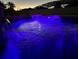 Serene night view of the pool featuring a waterfall, and lit with vibrant purple lights for a relaxing ambiance at 698 Mt Pleasant Dr, Ocoee, FL 34761