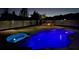 Night view of a backyard pool and jacuzzi with blue lighting and an inviting fire pit area for relaxation and entertainment at 698 Mt Pleasant Dr, Ocoee, FL 34761