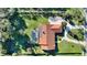 Aerial view of house with terra cotta roof, screened pool, and verdant backyard at 1000 Dunhurst Ct, Longwood, FL 32779