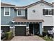 Two-story townhome with dark brown garage doors and a landscaped front yard at 1720 Garden Sage Dr, Oviedo, FL 32765