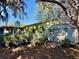 An exterior view of the back of the home, highlighting the backyard with mature landscaping at 403 Tranquille Oaks Dr, Ocoee, FL 34761