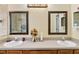 Bright bathroom featuring double sinks with a shower and a doorway visible in the large mirror at 4925 Cedarstone Ln, Orlando, FL 32822