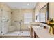 Bright bathroom features a large shower with glass door, seat and grab bars for added safety at 4925 Cedarstone Ln, Orlando, FL 32822