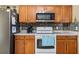 Bright kitchen with wood cabinetry, stainless steel appliances, and tile backsplash at 4925 Cedarstone Ln, Orlando, FL 32822