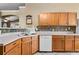 Spacious kitchen featuring wood cabinetry, a white dishwasher, and colorful tile backsplash at 4925 Cedarstone Ln, Orlando, FL 32822