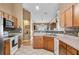 Well-lit kitchen featuring wood cabinetry, tiled flooring, and an attractive backsplash design at 4925 Cedarstone Ln, Orlando, FL 32822