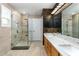 Bathroom with wood cabinets, dual sinks, white countertop, large mirror and glass enclosed shower at 723 Long Lake Dr, Oviedo, FL 32765
