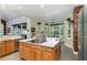 Spacious kitchen with stainless steel appliances, wood cabinets, island with cooktop and white countertop and barstool seating at 723 Long Lake Dr, Oviedo, FL 32765