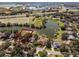 Aerial view of a residential area with a serene lake, surrounded by lush trees and well-maintained homes at 1845 Farrington Dr, Lakeland, FL 33809