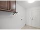 Laundry room with tile flooring, overhead cabinets and exterior door at 1845 Farrington Dr, Lakeland, FL 33809