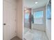 Bright bathroom featuring a glass-enclosed shower, gray tile flooring, and a window for natural light at 678 Fiddlesticks Dr, Davenport, FL 33837