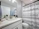 Stylish bathroom with modern vanity, quartz countertop, and black and white shower curtain at 678 Fiddlesticks Dr, Davenport, FL 33837